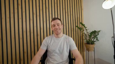 Businessman talks to friend on video call getting surprised to see girlfriend coming to office. Young man hugs woman feeling happy from POV to third party