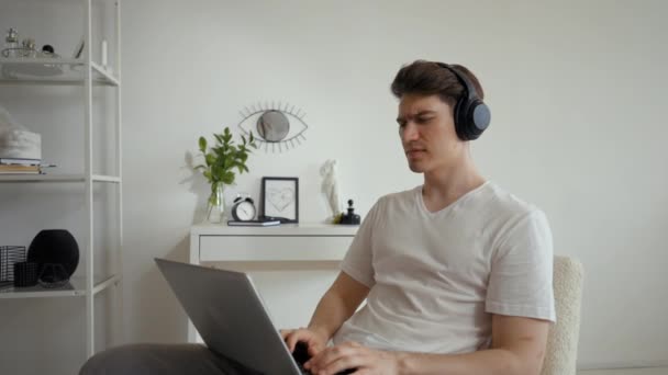 Man Headphones Listens Favorite Song Sitting Chair White Wall Young — Stock videók