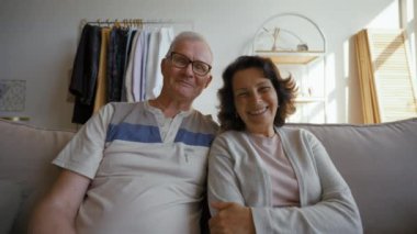 Elderly couple talks on video call via webcam with friends smiling. Senior man and woman distract on grandchildren coming to hug from POV to third party