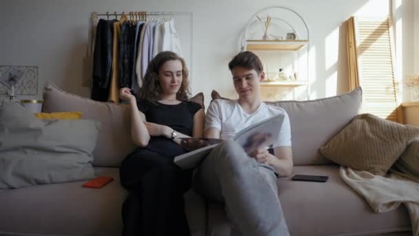 Young Couple Sits Couch Watching Wedding Album Remember Moments Happy — Stockvideo