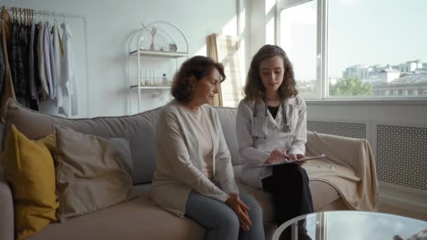 Young Therapist Discusses Health Problems Senior Woman Sitting Sofa Home — Stockvideo