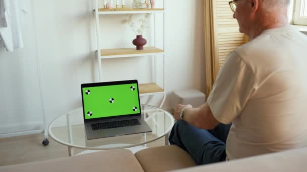 Senior Man Sits Couch Watching Sports Game Laptop Chromakey Screen — Stockvideo