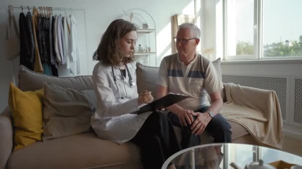 Lady Therapist White Coat Discusses Treatment Plan Elderly Man Doctor — Video Stock