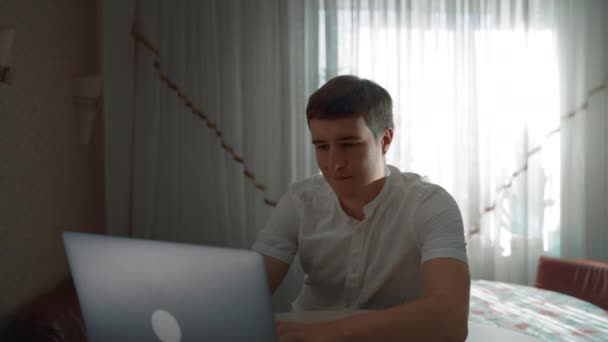 Concentrated Freelancer Sits Table Looking Modern Laptop Bright Window Young — Vídeo de stock