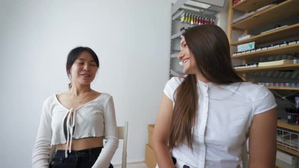 Young Women Enjoy Conversation Workplace Rack Items Brunette Lady Turns — Vídeo de stock