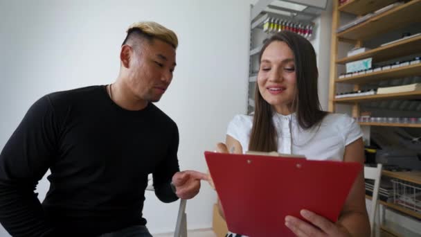 Female Manager Writes Notes Notepad Giving Asian Blond Dyed Man — Stock videók