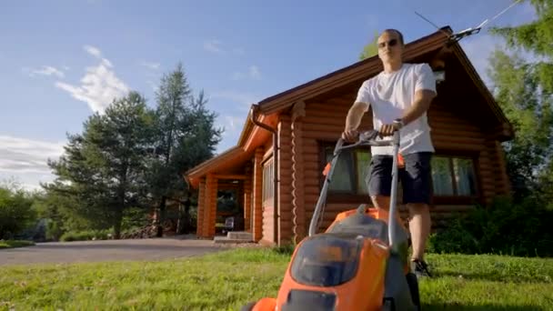 Middle Aged Man Wearing Glasses Cuts Grass Mower Cottage Yard — Video