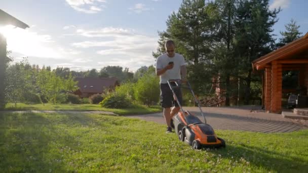 Mature Man Takes Mower Cut Grass Cottage House Middle Aged — Stockvideo