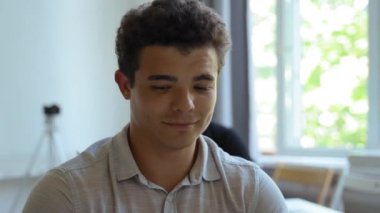 Young man sits at desk in audience listening to mentor at business conference. Employee with colleagues learn new skills closeup slow motion