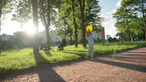 Toddler Boy Plays Ball Walking Pathway Child Throws Ball Trees — Vídeos de Stock