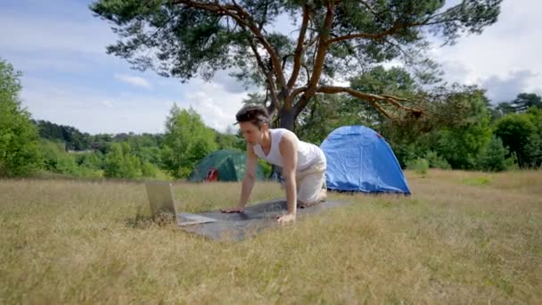 Young Man Does Yoga Mat Watching Online Stream Laptop Athletic — Stok video