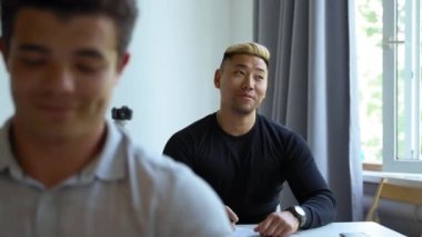 Young men sit at educational business conference in audience listening to mentor. Employees develop personal skills for better work closeup