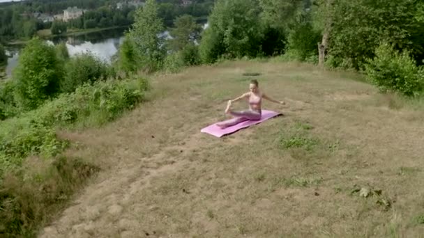 Young Woman Practices Yoga Pose Raising Arm Leg Upward Simultaneously — Video