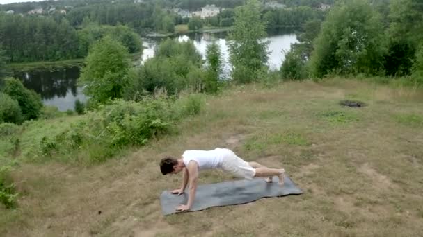 Young Athletic Man Performs Yoga Bow Pose Grassy Meadow Concentrated — 图库视频影像