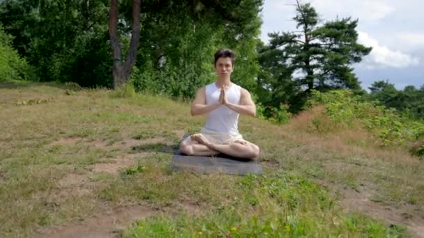 Young Athletic Man Meditates Lotus Pose Namaste Closing Eyes Grassy — 图库视频影像