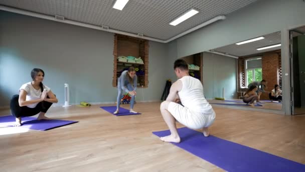 Erkek Koç Kadınlara Modern Stüdyoda Yoga Pozisyonunda Mavi Minderlerin Üzerinde — Stok video