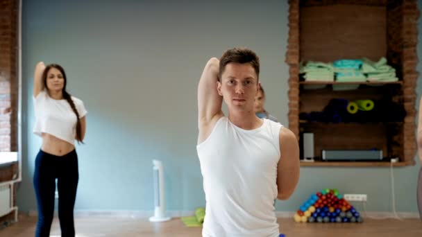 Entrenador Masculino Enseña Las Mujeres Jóvenes Estirar Cuerpo Clase Yoga — Vídeo de stock