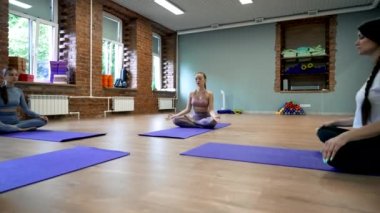 Stüdyoda Lotus 'ta otururken öğrencilerle poz vermekten çayırda meditasyon yapan kadınlara geçiş. İnsanlar yoga eğitimini seviyor.