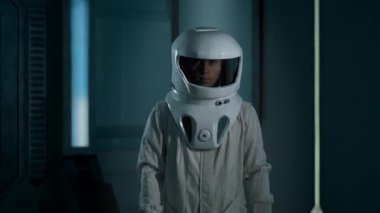 Uzay gemisinde kask takan bir astronotun portresi. Kendine güvenen genç bir astronot gelip kameraya bakar..