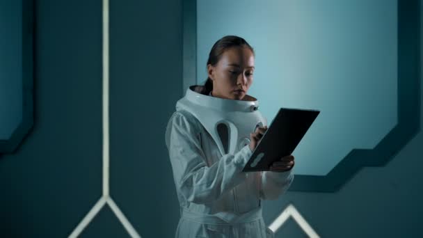 Eine Frau Futuristischen Anzug Gibt Daten Auf Einem Tablet Ein — Stockvideo