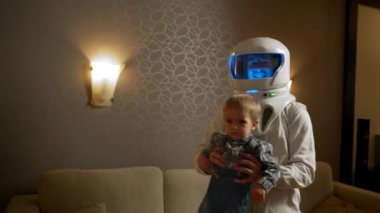Astronot evinde bir tatil sırasında oğluyla dans eder. Astronot miğferi takmış mavi arka planı olan bir adam bir çocukla vakit geçirir..