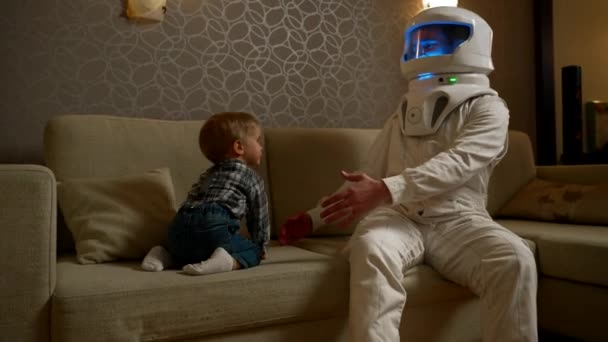 Peuter Klimt Bank Van Zijn Vader Een Astronautenkostuum Spelen Ruimtevaart — Stockvideo