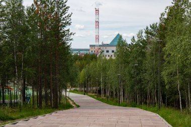 Noyabrsk şehrinin merkez parkından güzel bir binaya taş döşenmiş bir patika.