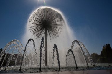 Eski parktaki güneş ışınlarının altında güzel bir çeşme