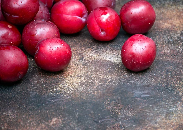 Les prunes de Bourgogne sont dispersées sur la table en gouttelettes d'eau. — Photo