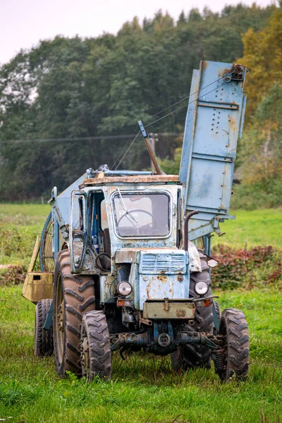 Oude vintage blauwe trekker op het platteland. — Stockfoto