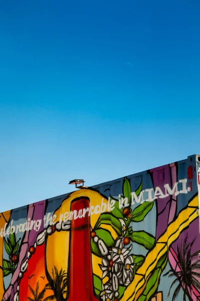 Utangaç ay, öğleden sonra gökyüzünde renkli bir duvarın üzerinde yükseliyor.