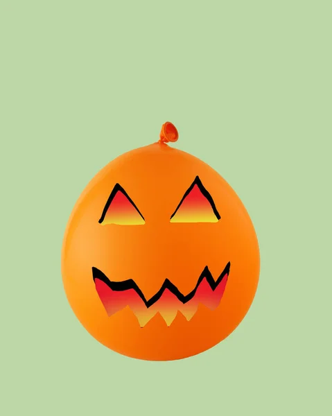 Pomerančový Balón Jako Dýně Nakresleným Zlým Obličejem Zeleném Pozadí — Stock fotografie
