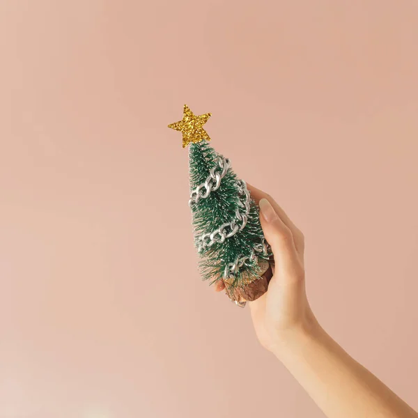 Ένα Χέρι Κρατά Ένα Χριστουγεννιάτικο Δέντρο Μια Αλυσίδα Ροζ Παστέλ — Φωτογραφία Αρχείου