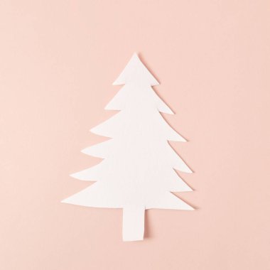 Pastel pembe arka planda beyaz kağıt Noel ağacı.