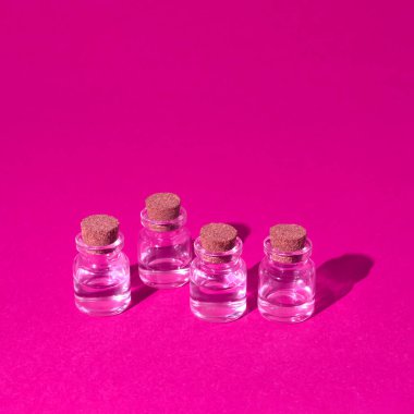 Mor arka planda sıralanmış cam şişeler. Canlı renkler