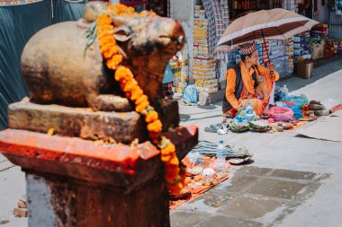 Kathmandu,Nepal - Aug 12, 2022 : A Hindu Priest waiting for visitors at the temple premises during Janai Purnima or rakshya Bandhan festival in Kathmandu. On this Festival day people ties holy thread from priest or hindu brahmins on their wrist.