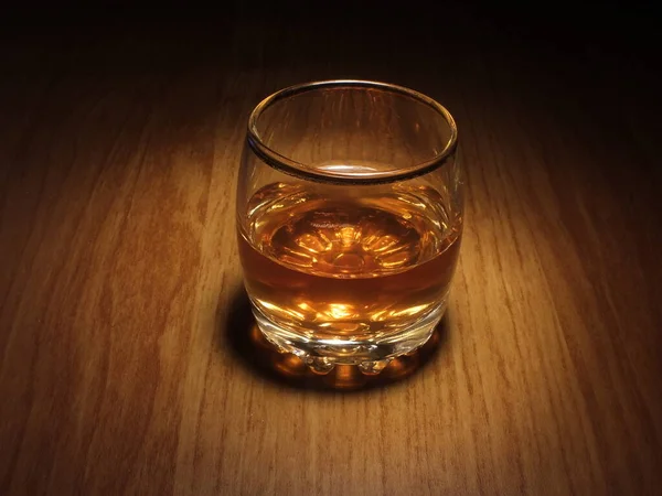 Tahta bir masada bir bardak viski.