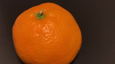 Yeni yıl mandalinası siyah bir masada dönüyor.