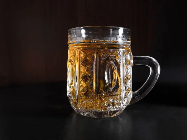 Ahşap arka plan ile ahşap masa üzerinde hafif bira Cam