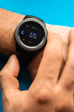 Bir adamın elindeki akıllı saat ekranda uyku saati gösteriyor. Bileğinde siyah bir saat olan erkek eller. İyi uykular. Yüksek kalite fotoğraf