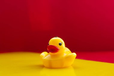 Sarı, kırmızı dudaklı, sarı-kırmızı arka planda sarı lastik ördek, mesaj için yer var. Sarı oyuncak ördek. Yapay büyük dudaklar. Botoks dudaklar. Ördek dudağı. Uzayı kopyala Yüksek kalite fotoğraf