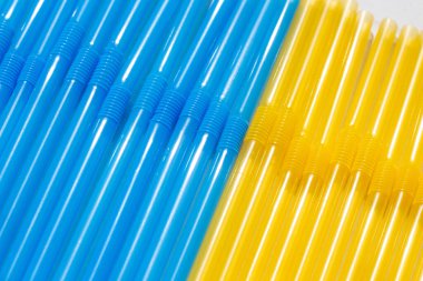 Ukrayna bayrağı renginde kokteyller için plastik pipetler. Mavi ve sarı kokteyl tüpleri yakın plan.
