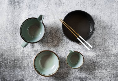 Masada boş tabak seti var. Masa takımı. Mutfak gereçleri ve aletleri.