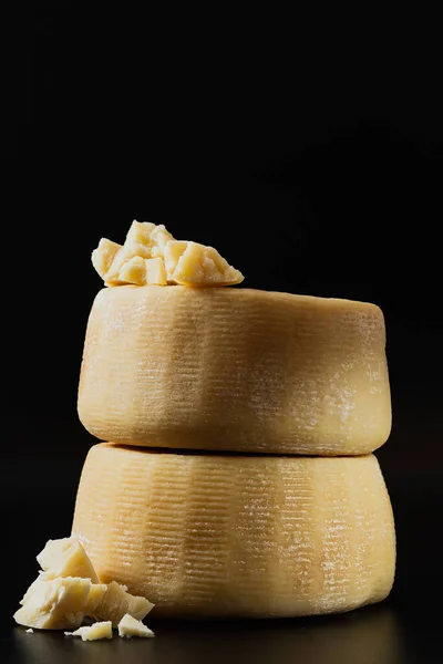 whole italian parmesan or pecorino cheese on a dark background. packaging advertising