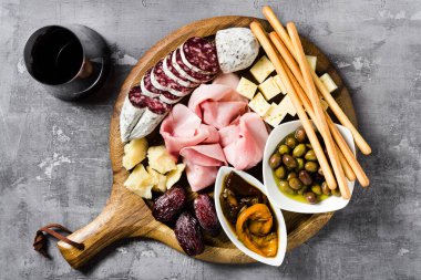 İtalyan aperatifi ve kırmızı şarap: prosciutto, salam, güneşte kurutulmuş domates, zeytin, peynir, Grissini ve hurma. Yaz atıştırması