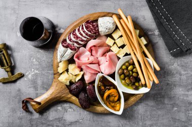 İtalyan aperatifi ve kırmızı şarap: prosciutto, salam, güneşte kurutulmuş domates, zeytin, peynir, Grissini ve hurma. Yaz atıştırması