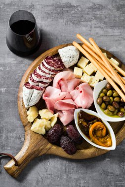 İtalyan aperatifi ve kırmızı şarap: prosciutto, salam, güneşte kurutulmuş domates, zeytin, peynir, Grissini ve hurma. Yaz atıştırması