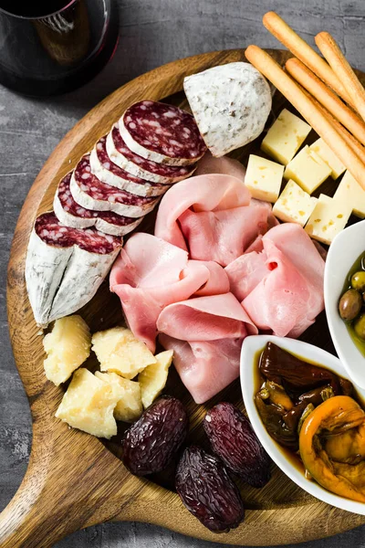 İtalyan aperatifi ve kırmızı şarap: prosciutto, salam, güneşte kurutulmuş domates, zeytin, peynir, Grissini ve hurma. Yaz atıştırması