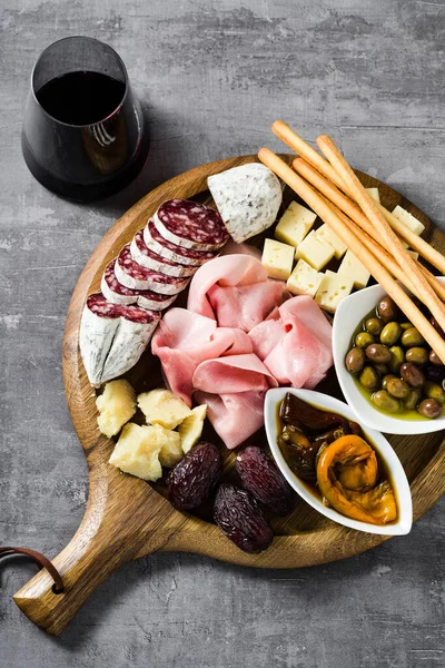 İtalyan aperatifi ve kırmızı şarap: prosciutto, salam, güneşte kurutulmuş domates, zeytin, peynir, Grissini ve hurma. Yaz atıştırması