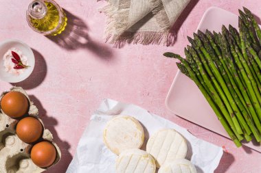 Masada yumurtalı ve peynirli taze kuşkonmaz ve malzeme. Bahar mevsimi tarifleri